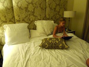 Woman in comfortable plush bed using laptop